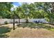 Spacious backyard featuring a white fence, mature trees, blue Adirondack chairs, and a charming swing at 108 S Glenwood Ave, Orlando, FL 32803