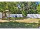 Spacious backyard featuring a white fence, mature trees, blue Adirondack chairs, and a charming swing at 108 S Glenwood Ave, Orlando, FL 32803