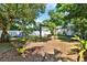 Large backyard with a wooden swing set, privacy fence, mature trees, and garden area at 108 S Glenwood Ave, Orlando, FL 32803