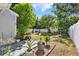 Secluded backyard featuring a covered patio area, beautiful greenery, and a white fence at 108 S Glenwood Ave, Orlando, FL 32803