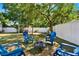 Secluded backyard featuring a wooden swing set, privacy fence, mature tree, blue Adirondack chairs, and a fire pit at 108 S Glenwood Ave, Orlando, FL 32803