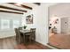 Charming dining room with wood table, four chairs, and wood beam ceilings adjacent to living room at 108 S Glenwood Ave, Orlando, FL 32803