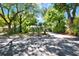 View of single-story home from across street, featuring mature trees, palms and landscaping at 108 S Glenwood Ave, Orlando, FL 32803