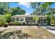 Charming single-story home featuring a screened porch, potted plants, and mature landscaping at 108 S Glenwood Ave, Orlando, FL 32803