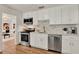 Modern kitchen featuring stainless steel appliances, white cabinets, and a view into the cozy living room space at 108 S Glenwood Ave, Orlando, FL 32803