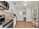 Bright kitchen featuring stainless steel appliances, white cabinets, tile backsplash, and wood-look flooring at 108 S Glenwood Ave, Orlando, FL 32803