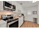 Bright kitchen featuring stainless steel appliances, white cabinets, tile backsplash, and wood-look flooring at 108 S Glenwood Ave, Orlando, FL 32803