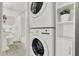 Convenient laundry area featuring a stacked washer and dryer, and built-in shelving for storage at 108 S Glenwood Ave, Orlando, FL 32803