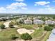 Sprawling golf course community with manicured greens, sand traps, and various condo buildings under a bright sky at 1112 Sunset View Cir # 302, Reunion, FL 34747