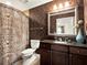 Charming bathroom featuring patterned wallpaper, dark wood vanity, and decorative shower curtain at 1112 Sunset View Cir # 302, Reunion, FL 34747