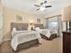 Bright bedroom with two twin beds, ceiling fan, and neutral decor, offering a cozy space at 1112 Sunset View Cir # 302, Reunion, FL 34747