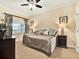 Comfortable bedroom with soft carpet, stylish bed, ceiling fan, and natural light from the window at 1112 Sunset View Cir # 302, Reunion, FL 34747