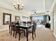 Bright dining area with a glass-top table, chandelier, and views of the balcony with sliding glass doors at 1112 Sunset View Cir # 302, Reunion, FL 34747