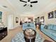 Open living room with blue sofas, a glass coffee table, and an adjacent dining area with elegant furnishings at 1112 Sunset View Cir # 302, Reunion, FL 34747