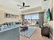 Cozy living room with balcony access, featuring comfortable seating, stylish decor, and a ceiling fan at 1112 Sunset View Cir # 302, Reunion, FL 34747