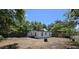 This backyard features a white exterior home with mature trees and a wood perimeter fence at 1125 W 8Th St, Lakeland, FL 33805