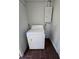 A simple laundry area with a white appliance and tiled floor provides homeowners with washing efficiency at 1125 W 8Th St, Lakeland, FL 33805