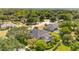 Spacious home with a screened-in pool, solar panels, surrounded by lush greenery, as seen from the air at 11401 Willow Stowe Ln, Windermere, FL 34786