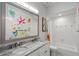 Bright bathroom with double sinks, granite countertops, a decorative mirror, and a tub/shower combo at 11401 Willow Stowe Ln, Windermere, FL 34786