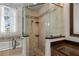 Shower room with tan tile surround and glass enclosure next to large soaking tub with transom window at 11401 Willow Stowe Ln, Windermere, FL 34786