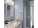 Stylish bathroom with a blue wall color featuring a white vanity with a marble countertop at 11401 Willow Stowe Ln, Windermere, FL 34786