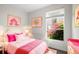 Charming bedroom featuring a pink bed, colorful artwork, and natural light from a window at 11401 Willow Stowe Ln, Windermere, FL 34786