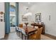Well lit dining room with modern chandelier, large window with blue curtains, and artwork on the walls at 11401 Willow Stowe Ln, Windermere, FL 34786