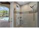 Modern bathroom features a glass shower with tile accents, a small window, and backyard pool access at 11401 Willow Stowe Ln, Windermere, FL 34786