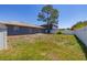 View of the backyard, showcasing fence lines, lush trees, patio and an exterior shot of the home at 1153 Perpignan Ct, Kissimmee, FL 34759