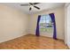 Bright bedroom featuring wood floors, a ceiling fan, and a large window at 1153 Perpignan Ct, Kissimmee, FL 34759