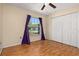 Bedroom features wood floors, a ceiling fan, a large window, and a closet at 1153 Perpignan Ct, Kissimmee, FL 34759