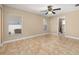Comfortable bedroom featuring tile floors, a ceiling fan, and plenty of natural light from two windows at 1153 Perpignan Ct, Kissimmee, FL 34759