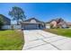 Wide driveway leading to a one-story home with an attached garage at 1153 Perpignan Ct, Kissimmee, FL 34759