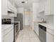 Functional kitchen featuring stainless steel appliances, white cabinets, and a stylish tile floor at 1153 Perpignan Ct, Kissimmee, FL 34759