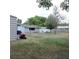 Spacious backyard with a view of the house, the shed, and a lawnmower at 1160 Rolling Acres Dr, Deland, FL 32720