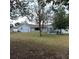View of the backyard with a patio, and a well-maintained lawn that provides ample space for outdoor activities at 1160 Rolling Acres Dr, Deland, FL 32720