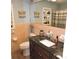 Bathroom with dark brown vanity, black marble countertop, and light pink tile walls at 1160 Rolling Acres Dr, Deland, FL 32720