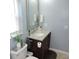 Cozy bathroom with a dark wood vanity with marble countertop and classic fixtures and fittings at 1160 Rolling Acres Dr, Deland, FL 32720