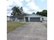 The landscaped front yard leads to this charming home with a gray garage at 1160 Rolling Acres Dr, Deland, FL 32720