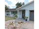 Inviting covered front porch with decorative planters, exterior house number, and stone landscaping around the walkway at 1160 Rolling Acres Dr, Deland, FL 32720