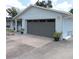 Light blue home with a gray attached garage and long concrete driveway and potted plants on either side of the garage door at 1160 Rolling Acres Dr, Deland, FL 32720