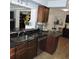 The open kitchen features dark granite countertops, stainless steel appliances, and warm wood cabinets at 1160 Rolling Acres Dr, Deland, FL 32720