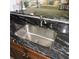 Granite countertops surround a stainless steel kitchen sink, complemented by custom wood cabinetry at 1160 Rolling Acres Dr, Deland, FL 32720