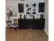 Living room showcasing a modern decor with floating shelves, dark cabinets, and wood-look tile flooring at 1160 Rolling Acres Dr, Deland, FL 32720