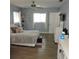 Bright main bedroom featuring light blue walls, wood floors, and lots of natural light at 1160 Rolling Acres Dr, Deland, FL 32720