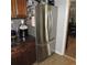 Stainless steel French door refrigerator complements the dark cabinets and granite countertops in the kitchen at 1160 Rolling Acres Dr, Deland, FL 32720