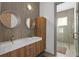 Stylish bathroom featuring double sinks, sleek wood cabinetry, and a glass-enclosed shower for a modern design at 11734 Lake Willis Dr, Orlando, FL 32821