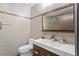 Modern bathroom featuring a wood vanity, sleek sink, mosaic-tile accents, and a frameless mirror at 11734 Lake Willis Dr, Orlando, FL 32821