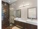 Sleek bathroom with double sinks, modern fixtures, and a walk-in shower with dark wood accents at 11734 Lake Willis Dr, Orlando, FL 32821