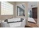 Modern bathroom includes a corner jacuzzi tub that looks out on an open bedroom with water views at 11734 Lake Willis Dr, Orlando, FL 32821